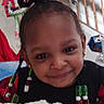 child, smiling, beads, hair, blanket, indoor, staircase, grinch, christmas, decoration, earrings, person, holiday, festive, home, portrait, cute, happy, cozy, black_clothing
