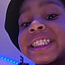 child, smiling, face, hat, indoor, blue_lights, tree, person, young, happy, teeth, portrait, casual, clothing, headwear, fun, expression, selfie, room, youth