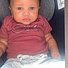 baby, child, car_seat, maroon_shirt, grey_shorts, face, eyes, infant, clothing, seat, person, young_child, indoors, cute, portrait, sitting, expression, young, skin, head