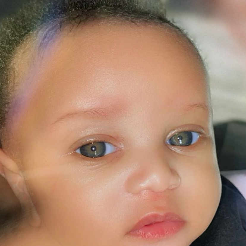 Loyal is registered to the contest to win money with this photo: baby, face, portrait, child, eyes, skin, expression, close_up, phone_screen, lock_screen, time_display, date_display, technology, infant, human, young, curious, indoor, soft_lighting, mobile_phone