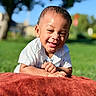 Issac joined the competition — help win amazing prizes! toddler, child, smiling, outdoor, grass, blanket, sunlight, happy, portrait, baby, nature, daylight, greenery, cute, face, casual_clothing, short_hair, park, playful, relaxed