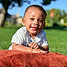 baby, child, smiling, outdoor, grass, blanket, sunlight, portrait, happy, nature, greenery, face, infant, cute, person, blue_sky, short_hair, white_shirt, daylight, warm