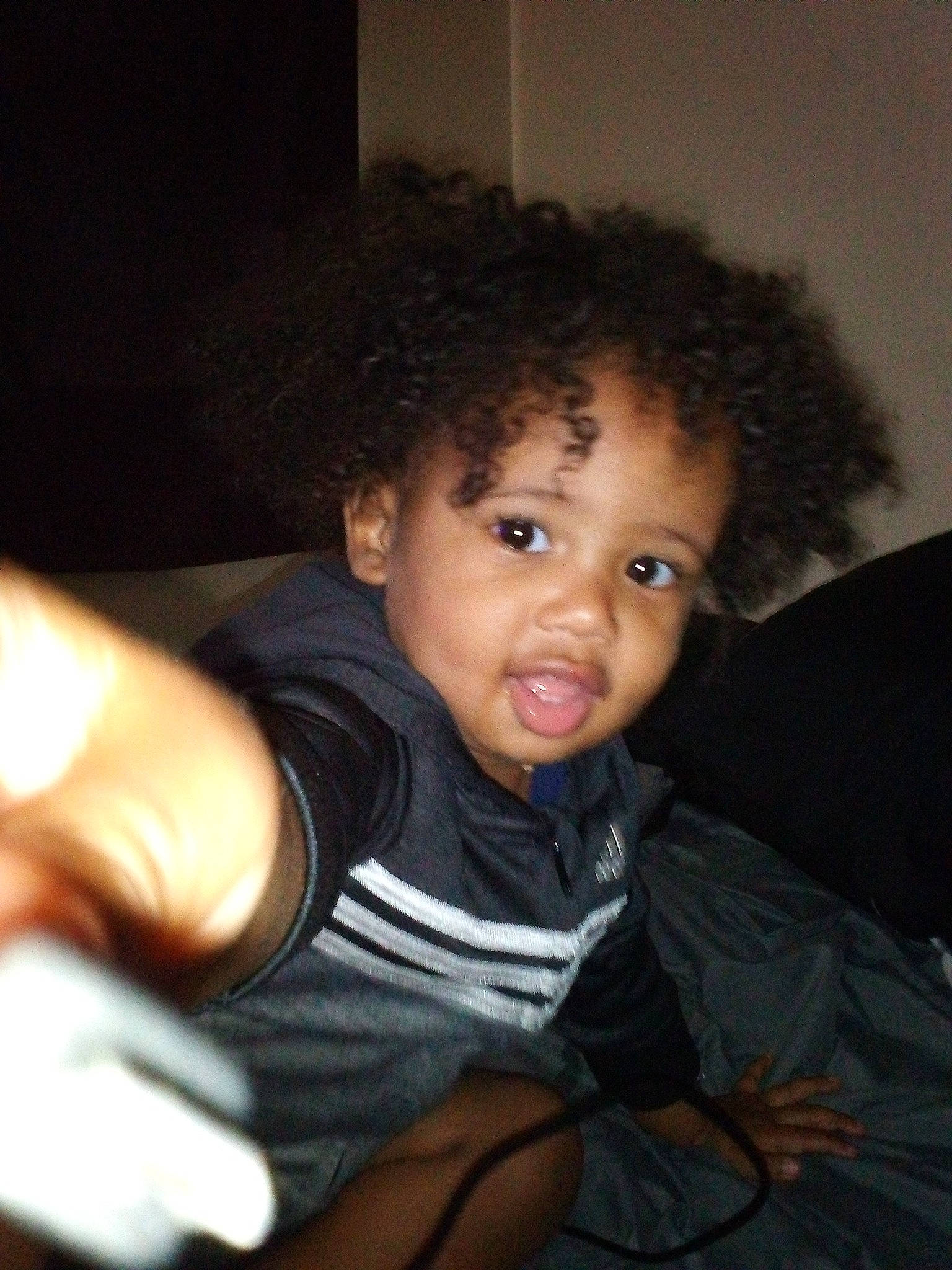 Landen is registered to the contest to win money with this photo: black_hair, cheek, comfort, elbow, eyebrow, flash_photography, fun, gesture, happy, human_body, lip, mouth, neck, nose, person, shoulder, sitting, t_shirt, thigh, thumb