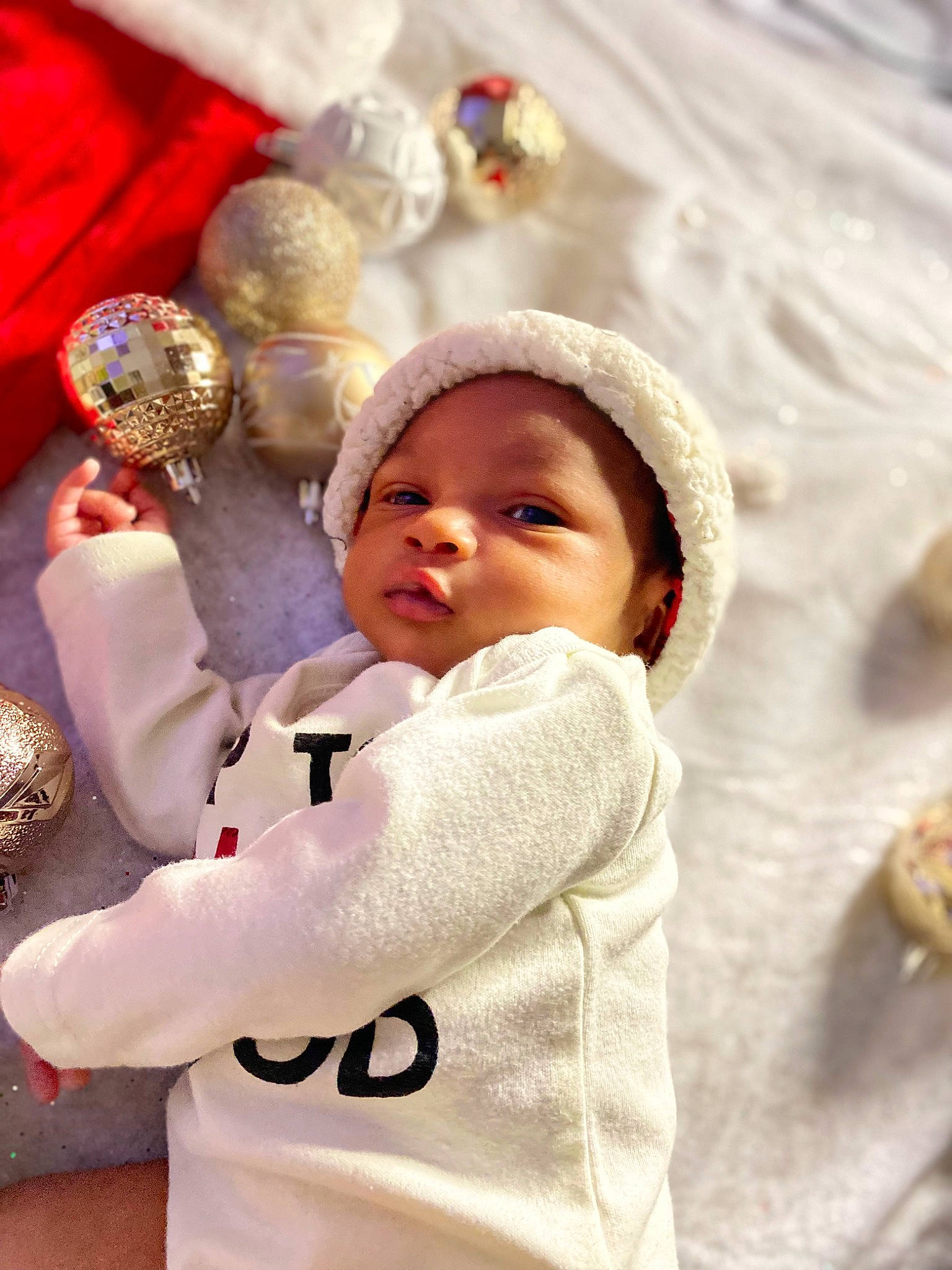 Montrez is registered to the contest to win money with this photo: baby, baby_sleeping, baby_toddler_clothing, child, christmas, christmas_ornament, event, facial_expression, fun, fur, happy, headwear, holiday, hoodie, knit_cap, linens, person, textile, toddler, tradition