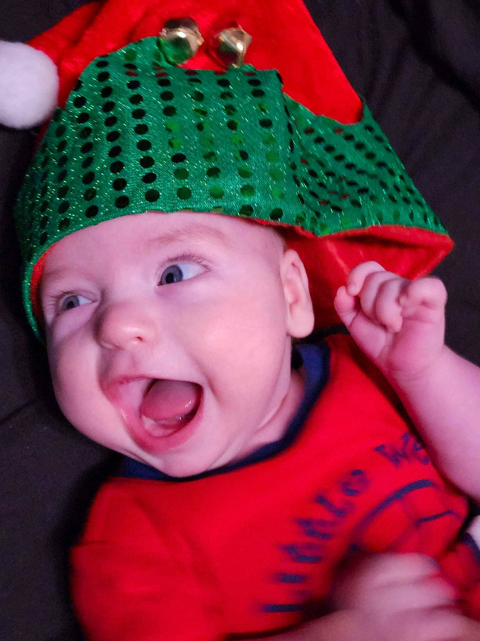 Anderson is registered to the contest to win money with this photo: baby, baby_toddler_clothing, cap, cheek, costume_hat, eye, face, facial_expression, finger, gesture, green, hand, hat, head, headwear, human_body, person, pink, red, skin