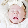 baby, newborn, infant, sleeping, headband, bow, white_clothing, blanket, basket, portrait, cute, mouth_open, eyes_closed, soft_texture, close_up, cheeks, skin, nursery, peaceful, face