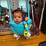 Jayce is registered to the contest to win money with this photo: baby, child, infant, sitting, jumper, activity_center, toy, plush_toy, stuffed_animal, smiling, wide_eyed, portrait, indoors, living_room, hardwood_floor, furniture, vacuum_cleaner, window, clothing, photography