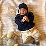 Arthur participe au concours pour gagner de l'argent avec cette photo : baby, infant, blanket, stuffed_animal, toy, bunny, hat, beanie, clothing, smile, face, hands, lying_down, white, navy, soft_toy, cute, infant_clothing, portrait, indoor