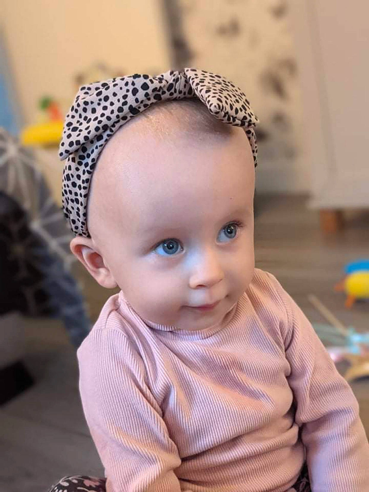 Lily-may is registered to the contest to win money with this photo: baby_toddler_clothing, beanie, cap, cheek, child, eyelash, fashion_accessory, fashion_design, flooring, hair_accessory, happy, headband, headgear, headpiece, knit_cap, pattern, person, skin, sleeve, toddler