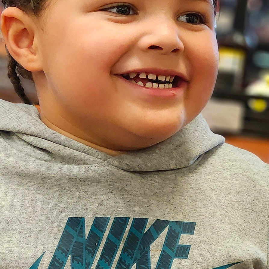 Dakylan is registered to the contest to win money with this photo: braided_hair, casual_wear, child, closeup, clothing, cute, expression, face, fashion, happy, hoodie, indoor, joyful, kid, nike_logo, person, portrait, smiling, sweatshirt, young