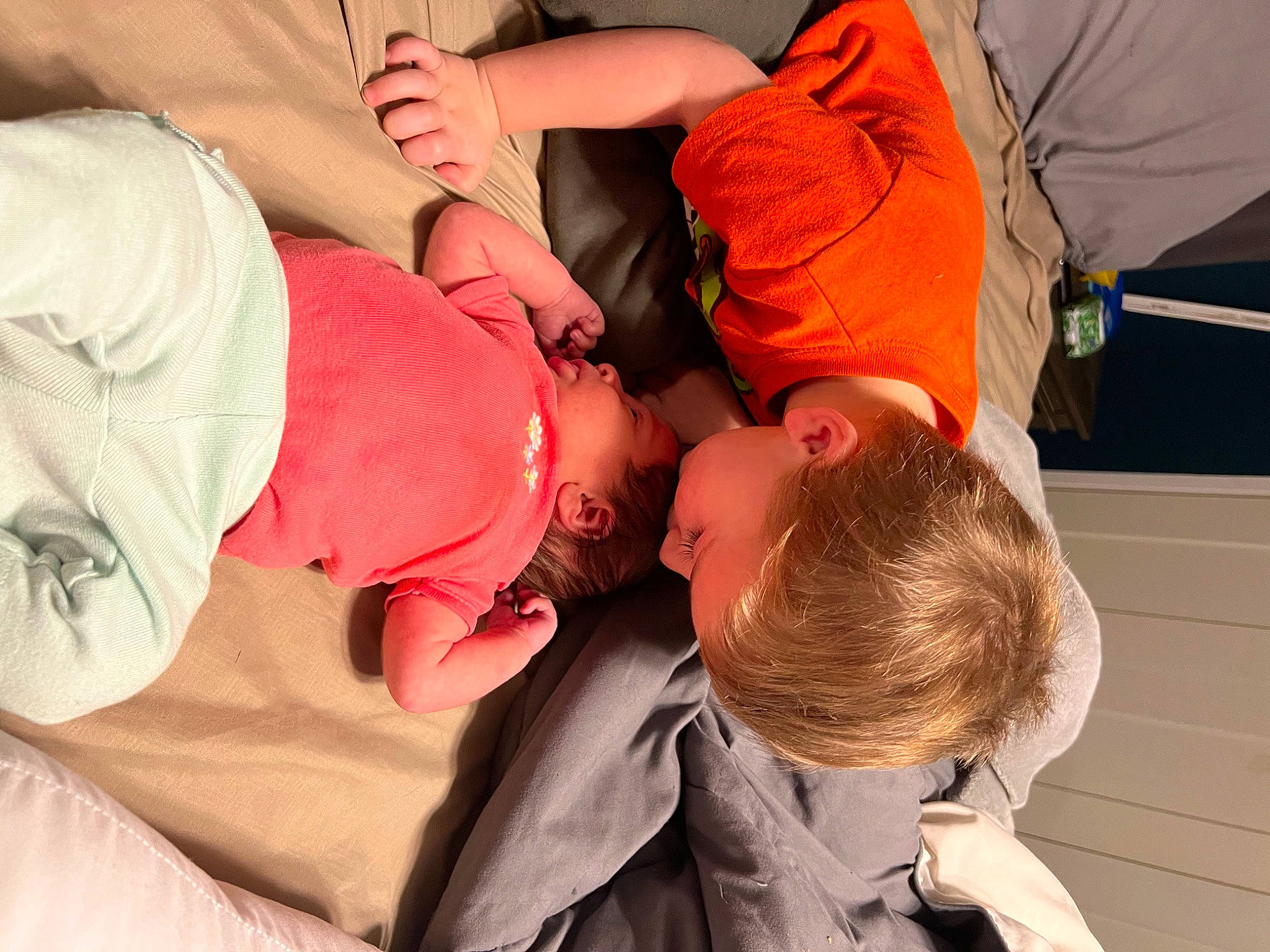 Nolan is registered to the contest to win money with this photo: abdomen, arm, baby, comfort, elbow, event, finger, fun, gesture, happy, hat, knee, mouth, orange, person, shorts, sitting, t_shirt, toddler, trunk