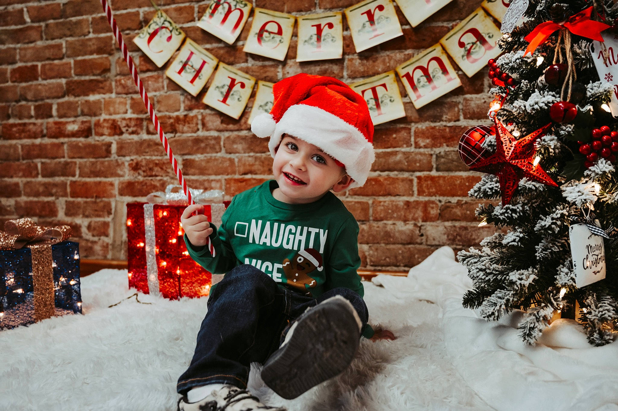 Nolan is registered to the contest to win money with this photo: christmas, christmas_decoration, christmas_eve, christmas_ornament, christmas_tree, event, facial_expression, freezing, fun, happy, head, headwear, holiday, jeans, joy, leaf, outerwear, person, sleeve, smile