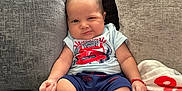 Alvaro is registered to the contest to win money with this photo: baby, clothing, couch, cushion, face, footwear, furniture, head, homedecor, hosiery, pants, person, photography, pillow, portrait, shoe, shorts, sitting, sock, t_shirt