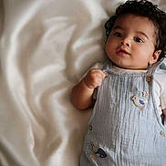 Caleb joined the competition — help win amazing prizes! baby, child, curly_hair, overalls, sea_creatures, whale, octopus, bird_patch, blanket, soft_texture, lying_down, cute, portrait, indoors, infant, clothing, person, skin, face, expression