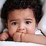 Caleb joined the competition — help win amazing prizes! baby, child, face, curly_hair, eyes, hand, fist, blanket, white, cute, innocence, portrait, close_up, skin, expression, soft, comfort, young, person, peaceful