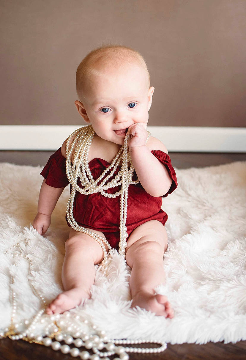 Autumn is registered to the contest to win money with this photo: baby, baby_toddler_clothing, cheek, child, child_model, dress, eye, face, fashion_accessory, fur, head, leg, person, photograph, photography, product, sitting, skin, smile, toddler