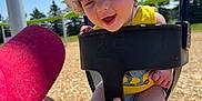 Flint joined the competition — help win amazing prizes! adult_hand, baby, beard, blue_sky, child, dinosaur_print, fun, happy, hat, outdoor, person, playground, red_cap, seat, smiling, sunny, swing, trees, woodchips, yellow_shirt