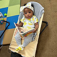 Remiri joined the competition — help win amazing prizes! baby, baby_chair, book, bow, carpet, child, clothing, cute, engaged, expression, feet, headband, indoor, infant, lemon_pattern, person, play_mat, reading, socks, toy
