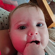 Jade a rejoint le concours — aidez-le/la à gagner de superbes lots ! baby, infant, close_up, face, hand, fingers, mouth, eyes, eyelashes, cheek, skin, pillow, blanket, bedding, furniture, wood_table, indoor, portrait, teething, drooling