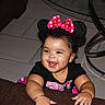 Amiry is registered to the contest to win money with this photo: toddler, child, smiling, minnie_mouse, headband, pink_bow, black_shirt, bracelet, curly_hair, indoor, glass_table, tiled_floor, happy, baby, person, cute, playful, joyful, furniture, home