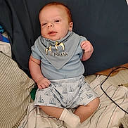 Silas joined the competition — help win amazing prizes! baby, infant, blue_clothing, bib, giraffe_print, socks, bed, blanket, striped_blanket, cute, child, person, indoor, lying_down, soft_lighting, newborn, resting, small_hands, small_feet, comfort