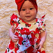 Violet Ann is registered to the contest to win money with this photo: baby, child, red_bow, headband, apple_print, dress, fluffy_blanket, smile, cute, infant, portrait, closeup, indoors, soft_texture, happy, chubby_cheeks, person, fashion, colorful, playful