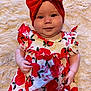 baby, child, red_bow, headband, apple_print, dress, fluffy_blanket, smile, cute, infant, portrait, closeup, indoors, soft_texture, happy, chubby_cheeks, person, fashion, colorful, playful