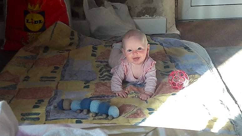 Iris participe au concours pour gagner de l'argent avec cette photo : baby, baby_products, bedding, bedtime, cardboard, carton, child, comfort, flooring, fun, linens, person, pillow, room, shipping_box, sitting, smile, textile, toddler, umbrella