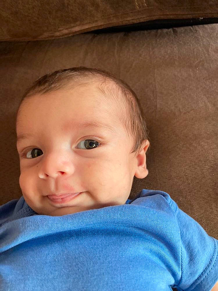 Giles is registered to the contest to win money with this photo: azure, baby, baby_toddler_clothing, cheek, ear, eyebrow, eyelash, flash_photography, forehead, human_body, iris, lip, mouth, neck, nose, person, skin, sleeve, smile, textile