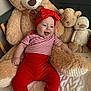 baby, child, teddy_bear, stuffed_animal, plush, red_clothing, striped_shirt, headband, smiling, indoors, bed, blanket, cozy, cute, happy, person, toy, soft, sitting, comfort