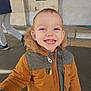 Aménadiel a rejoint le concours — aidez-le/la à gagner de superbes lots ! child, toddler, smile, jacket, fur_hood, teeth, face, portrait, outdoor, pavement, person, coat, happy, eyes, hand, ear, winter_clothing, zipper, wall, steps
