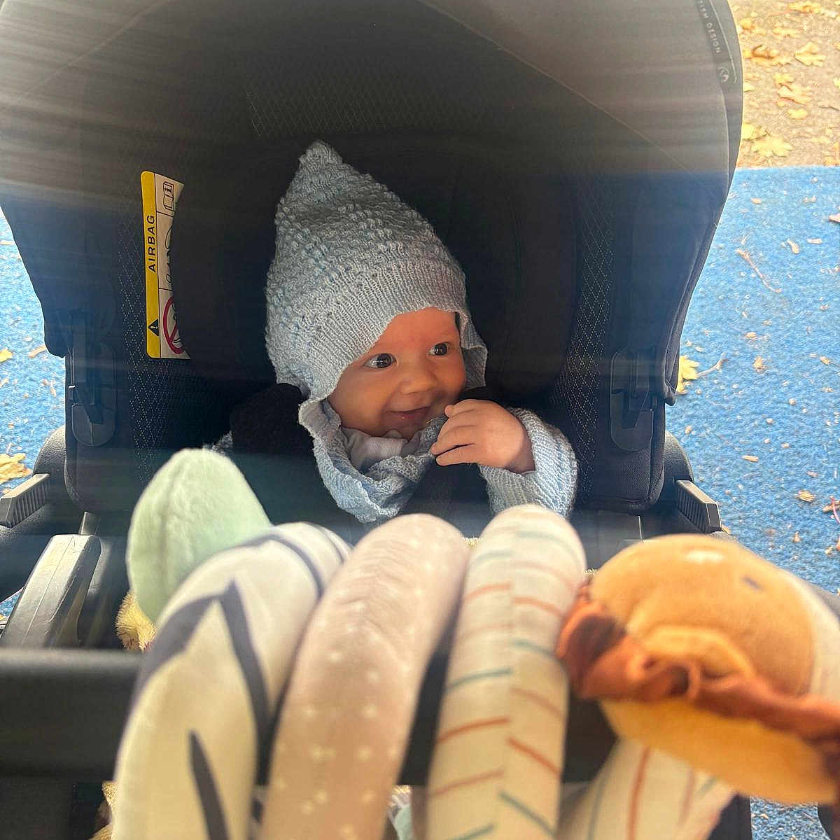 Elio joined the competition — help win amazing prizes! autumn, baby, child, childhood, cozy, cute, fabric, face, fall_leaves, hand, headwear, infant, knit_hat, outdoor, playground, seat, smile, stroller, toy, warm_clothing