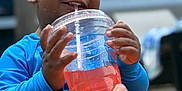 Khalil joined the competition — help win amazing prizes! child, toddler, drink, straw, blue_clothing, happy, smiling, hand, beverage, outdoor, summer, refreshing, closeup, cute, water_drops, sitting, person, skin, daylight, fun