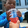 child, toddler, drink, straw, blue_clothing, happy, smiling, hand, beverage, outdoor, summer, refreshing, closeup, cute, water_drops, sitting, person, skin, daylight, fun