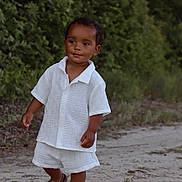 Khalil joined the competition — help win amazing prizes! toddler, child, outdoor, nature, greenery, sand, path, white_clothing, shorts, shirt, sandals, walking, smiling, cute, young_child, summer, portrait, person, happy, sunlight