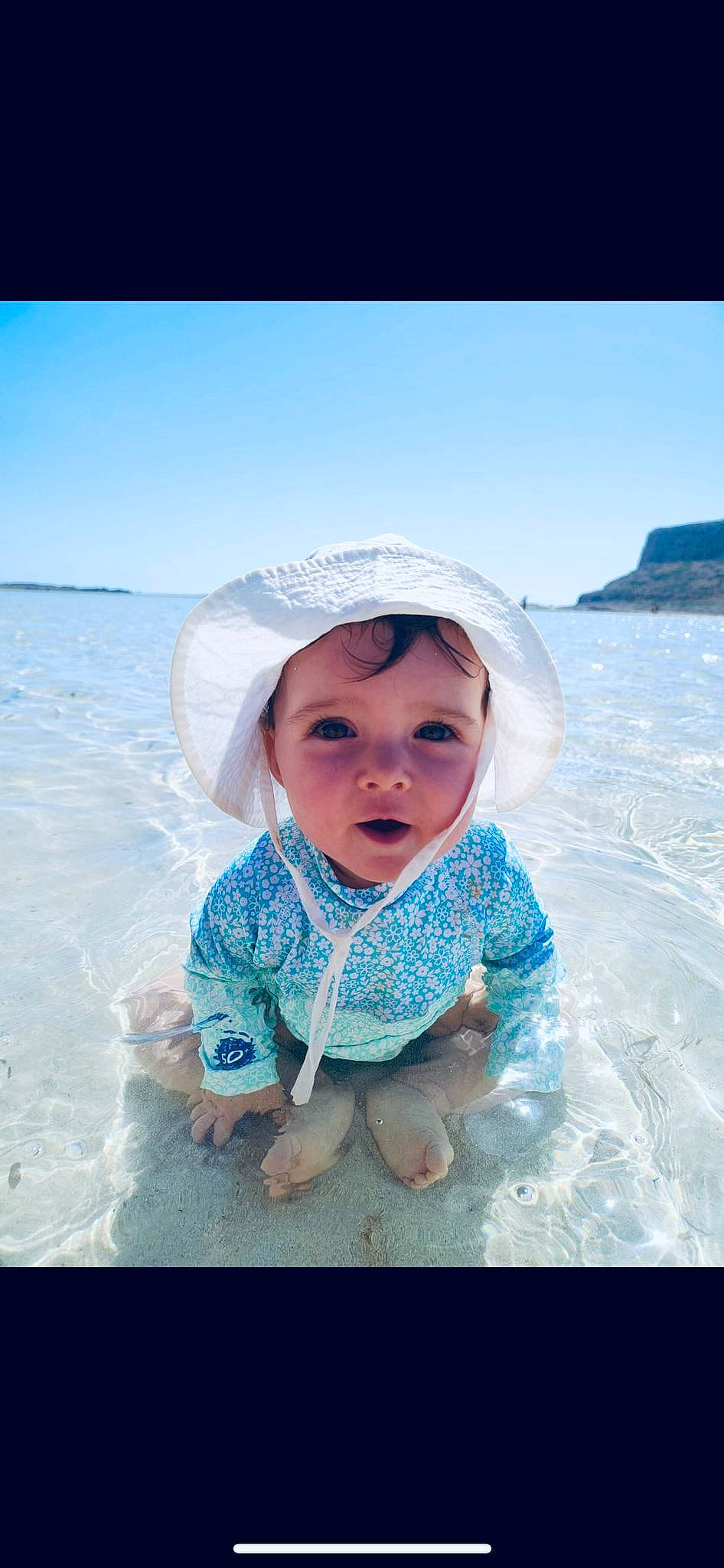 Norah a rejoint le concours — aidez-le/la à gagner de superbes lots ! aqua, azure, baby, beach, cloud, flash_photography, fun, happy, headwear, landscape, leisure, people_in_nature, people_on_beach, person, recreation, sand, skin, sky, sun_hat, toddler
