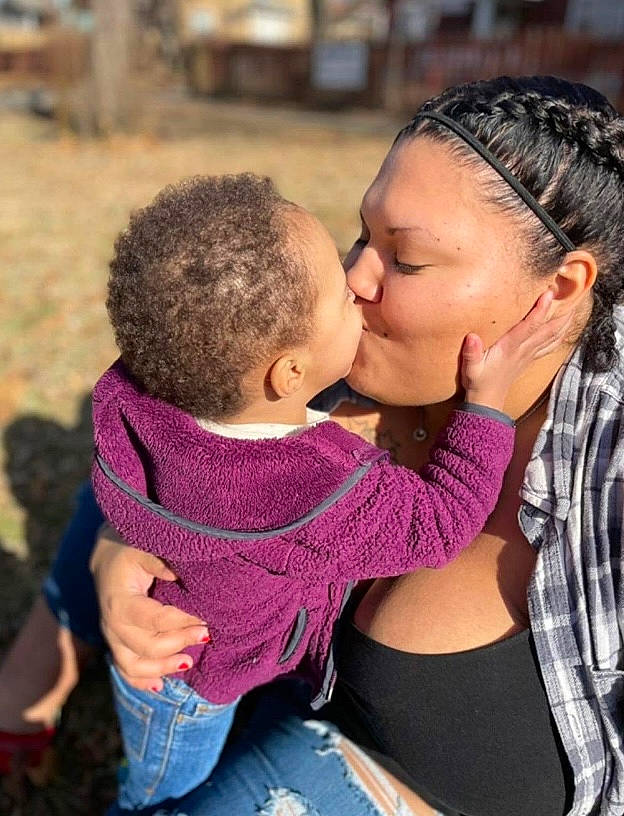 Ezra is registered to the contest to win money with this photo: baby, child, event, facial_expression, fun, gesture, grass, happy, hug, interaction, jewellery, kiss, leisure, love, people_in_nature, person, romance, shoulder, skin, toddler