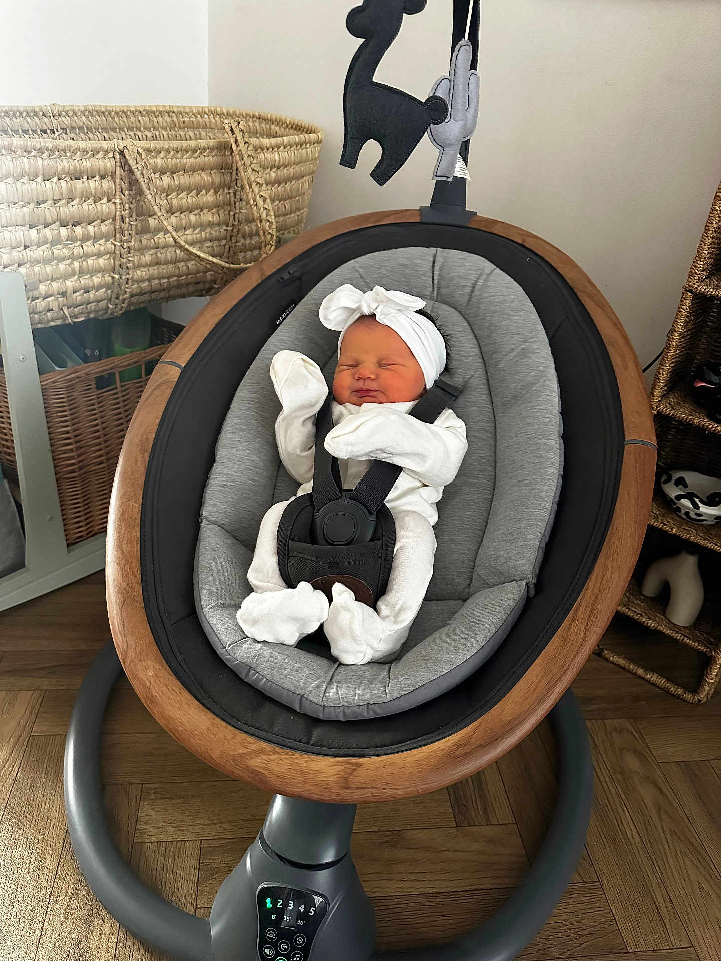 Remy is registered to the contest to win money with this photo: newborn, baby, sleeping, baby_rocker, headband, white_clothing, indoor, wooden_floor, basket, woven_basket, modern_furniture, baby_seat, infant, cozy, relaxed, child, soft_lighting, home, cute, peaceful