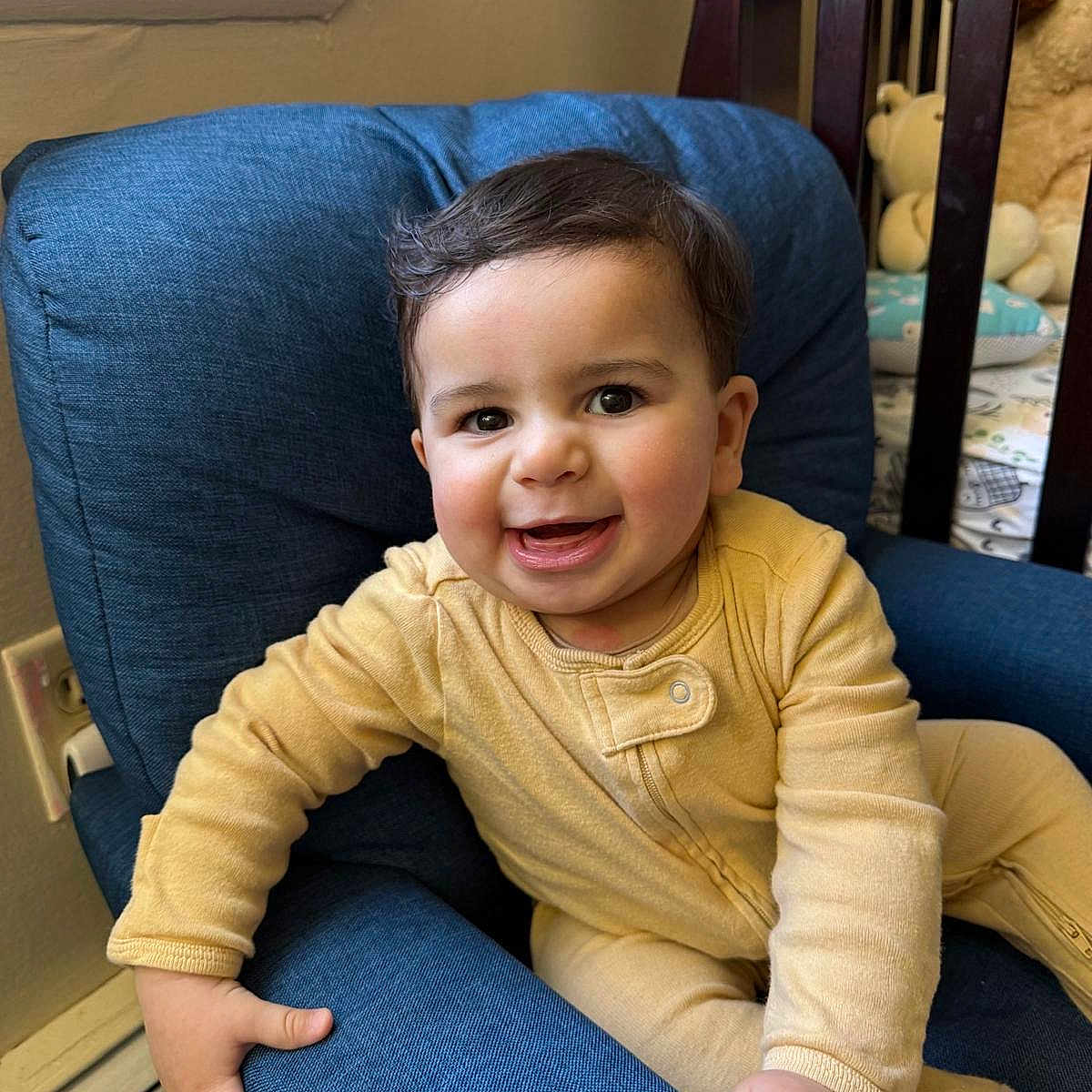 Faisal joined the competition — help win amazing prizes! baby, blue_chair, child, couch, crib, cute, face, furniture, hand, happy, home, indoor, infant, portrait, room, seat, smiling, stuffed_animals, window, yellow_onesie