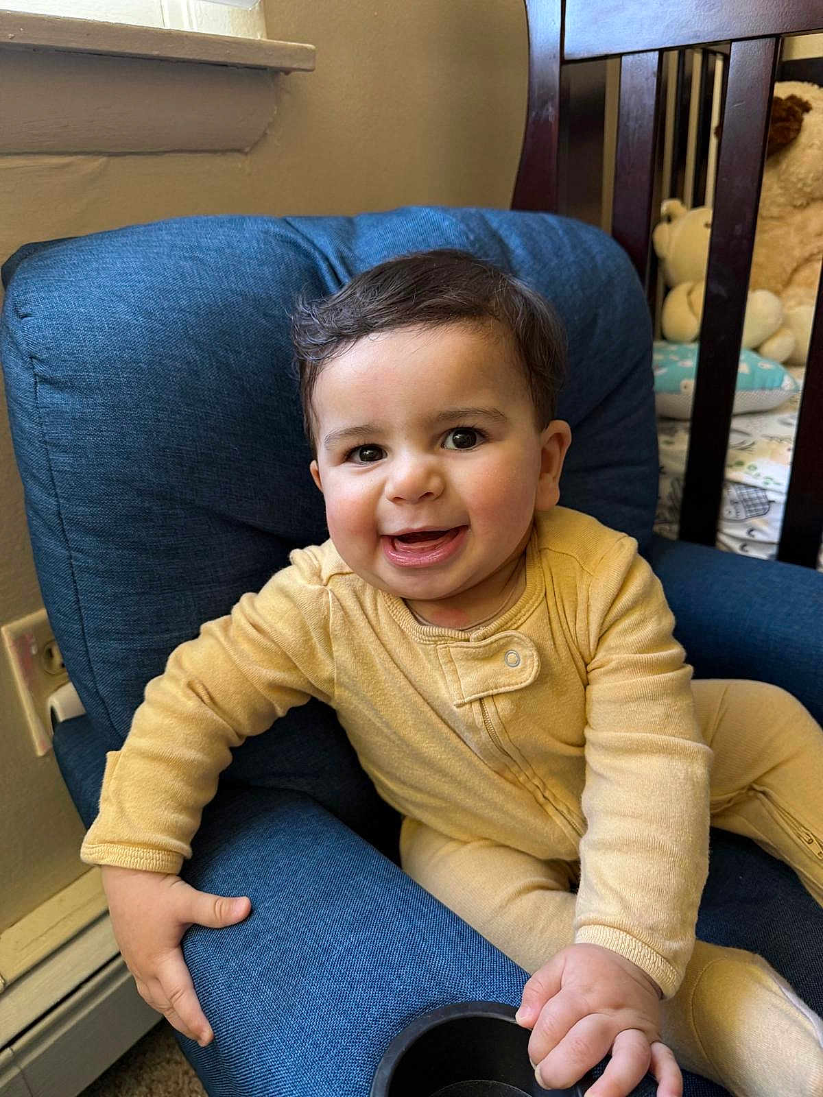 Faisal joined the competition — help win amazing prizes! baby, blue_chair, child, couch, crib, cute, face, furniture, hand, happy, home, indoor, infant, portrait, room, seat, smiling, stuffed_animals, window, yellow_onesie