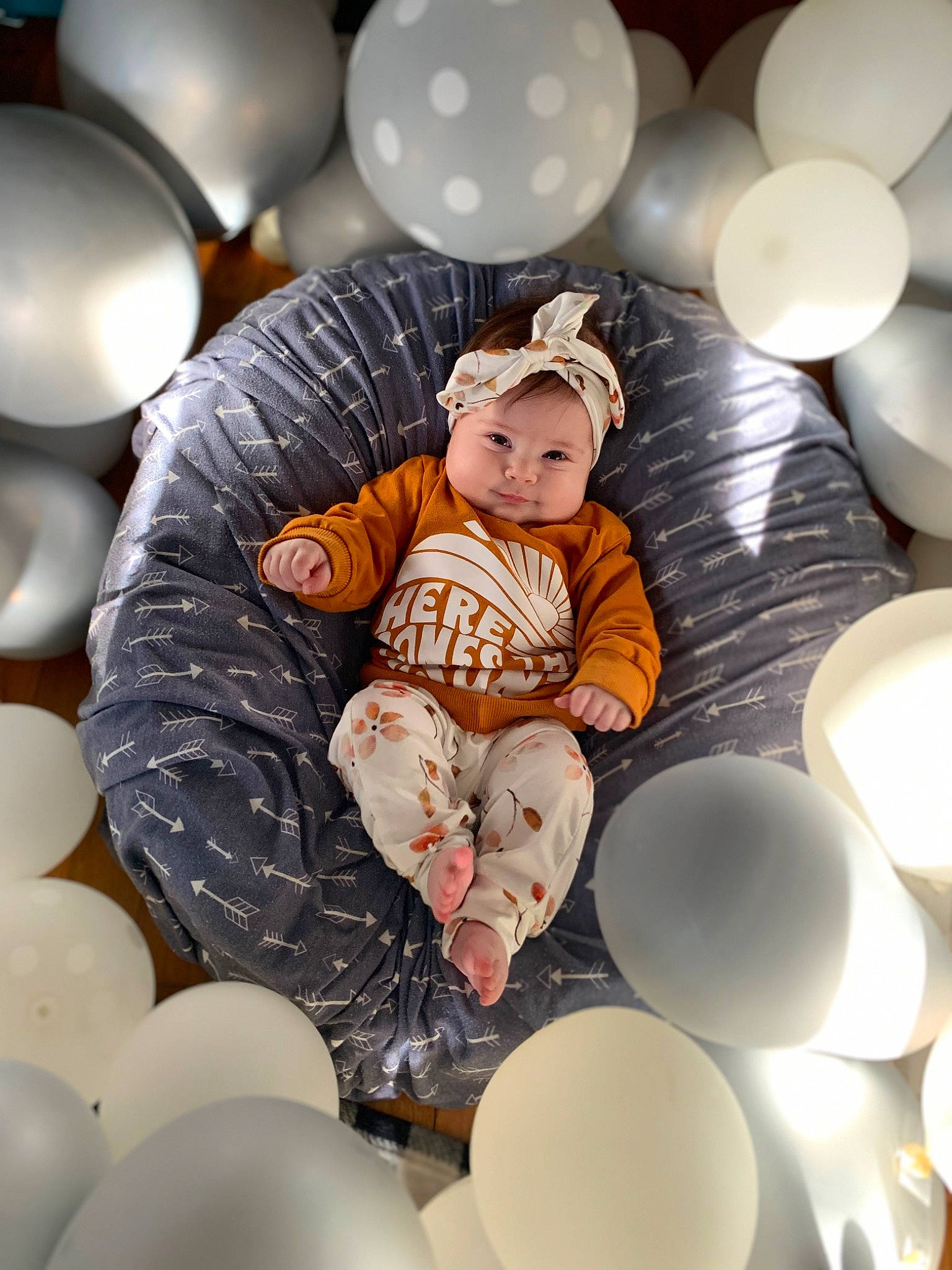 Ember is registered to the contest to win money with this photo: baby, baby_toddler_clothing, balloon, child, circle, comfort, design, event, fun, happy, hat, head, headwear, human, light, material_property, party_supply, person, recreation, sitting