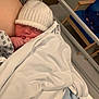 newborn, baby, infant, hospital, blanket, hat, sleeping, bed, bassinet, clothing, person, indoor, rest, cozy, cute, child, healthcare, quiet, peaceful, family