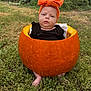 baby, child, pumpkin, orange_bow, headband, grass, outdoor, fall, autumn, cute, costume, nature, greenery, feet, black_clothing, seasonal, holiday, portrait, baby_in_pumpkin, expression