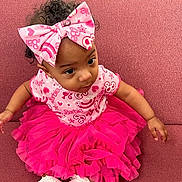 Kelani joined the competition — help win amazing prizes! baby, bow, child, clothing, couch, curious, cute, fashion, furniture, happy, headband, indoor, infant, person, pink, portrait, sitting, sock, tutu, young