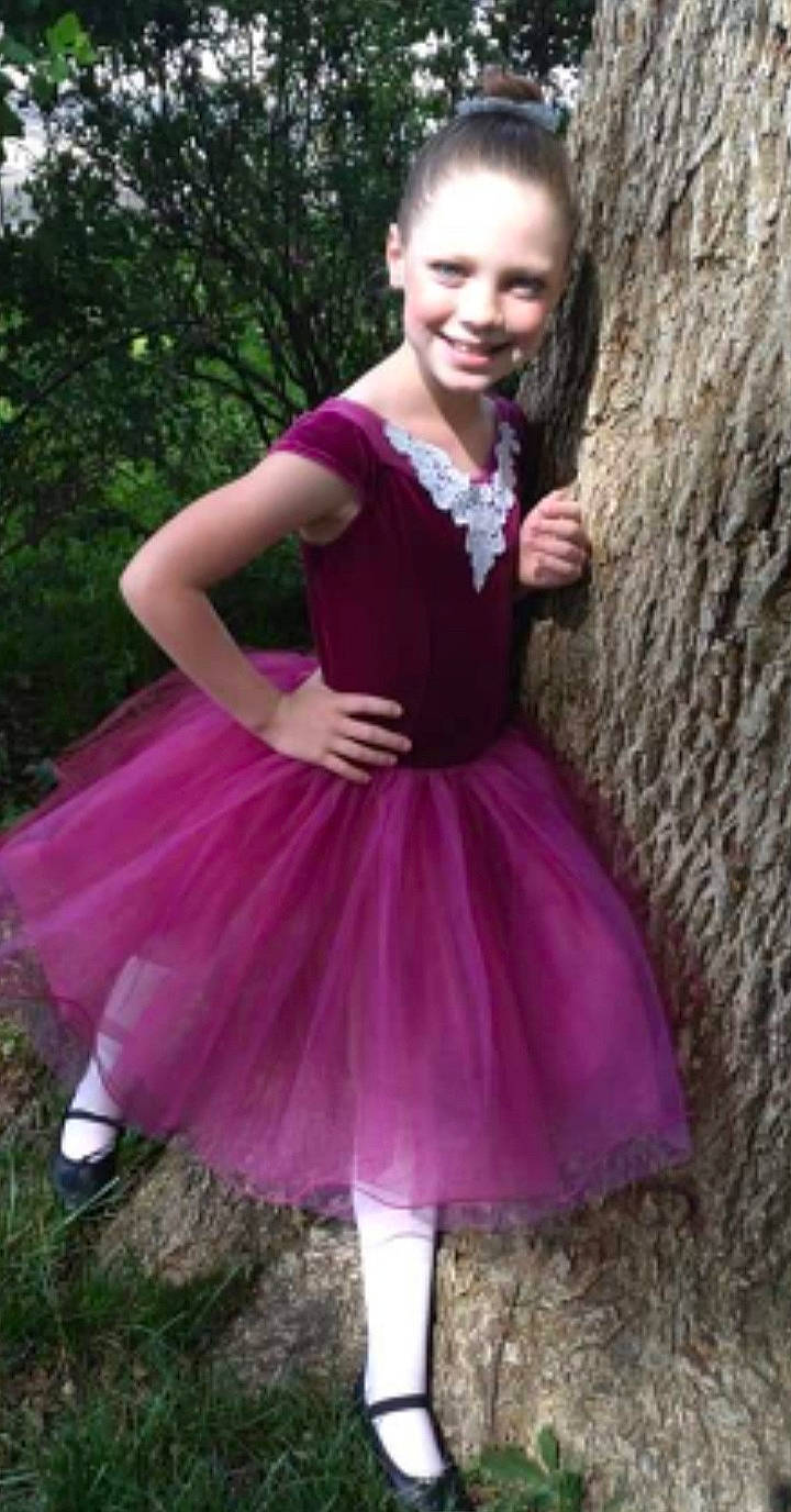 Karleigh is registered to the contest to win money with this photo: baby_toddler_clothing, day_dress, dress, electric_blue, formal_wear, grass, iris, jewellery, joy, magenta, person, pink, plant, purple, ruffle, shoe, sleeve, smile, tree, trunk