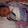 baby, bed, bedding, blanket, cat_pattern, child, cozy, face, indoors, infant, napping, newborn, pacifier, peaceful, pink, portrait, purple, sleeping, striped_clothing, swaddle