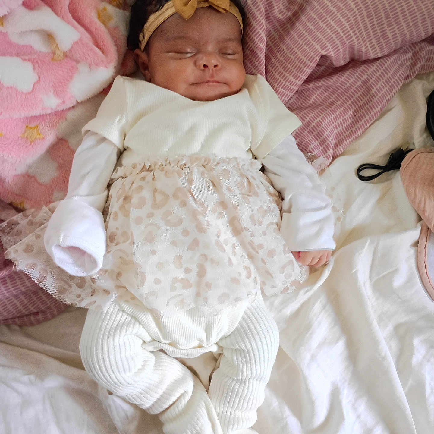 Mi'Angel is registered to the contest to win money with this photo: baby, sleeping, infant, headband, bow, white_clothing, dress, blanket, bed, pillow, pink, portrait, indoors, cozy, peaceful, newborn, lying_down, fashion, textile, family