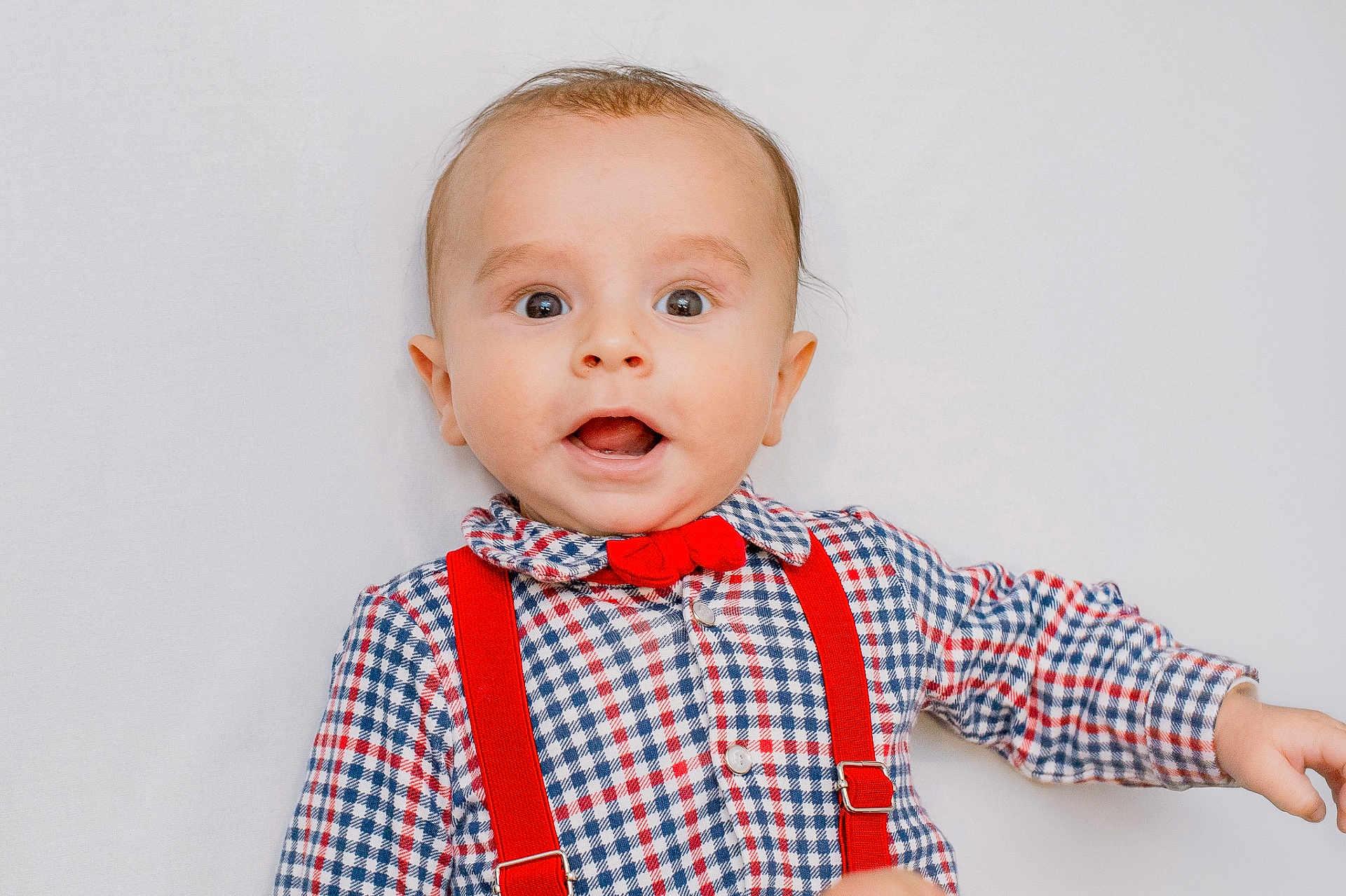 Chahan participe au concours pour gagner de l'argent avec cette photo : baby, child, face, expression, shirt, bow_tie, suspenders, plaid, red, blue, white_background, portrait, cute, young, person, smile, eyes, head, clothing, infant