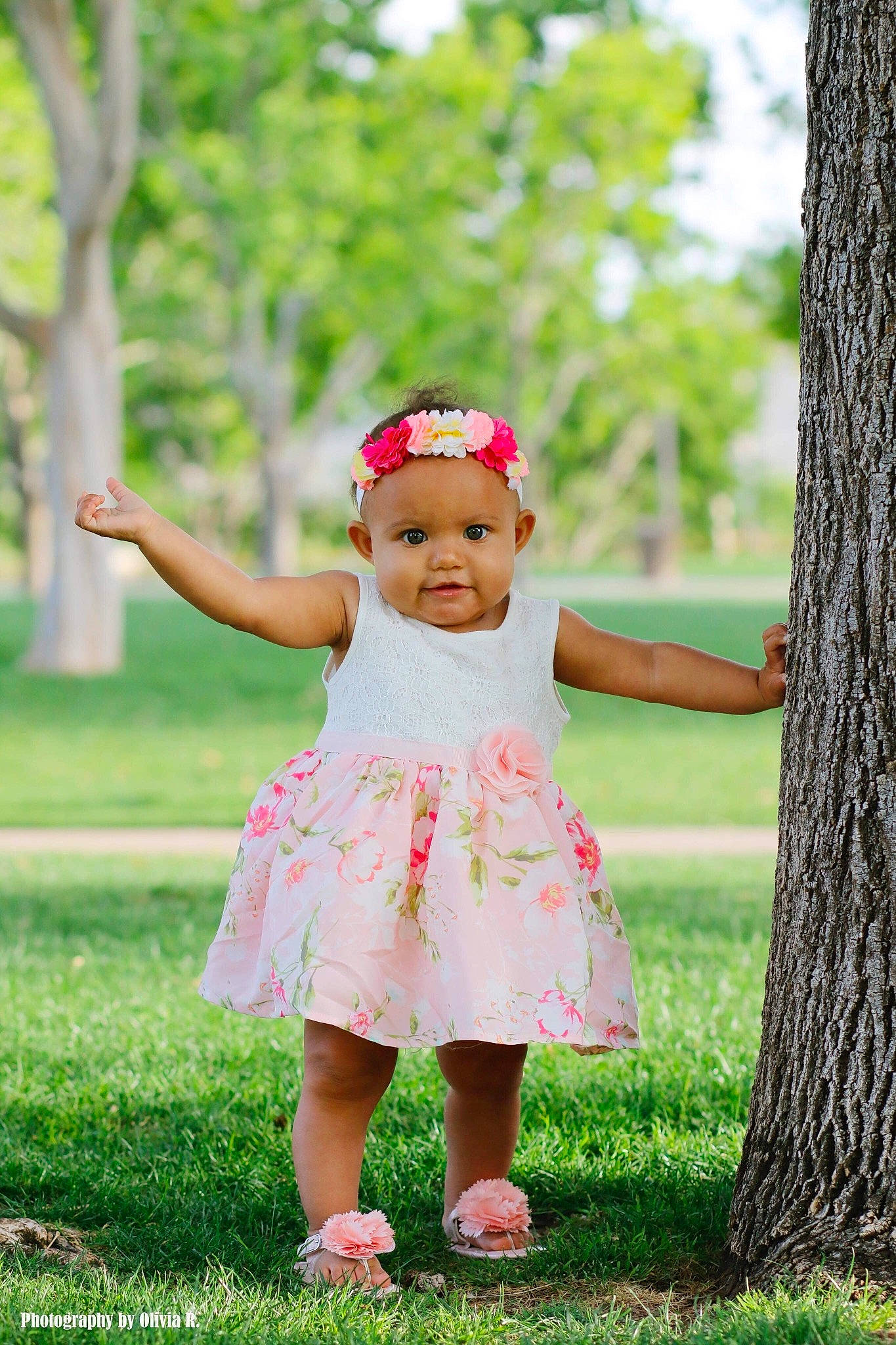 Stella is registered to the contest to win money with this photo: baby, baby_toddler_clothing, child, child_model, clothing, dress, grass, green, hair_accessory, headgear, pattern, people_in_nature, person, photograph, photography, pink, spring, summer, toddler, tree
