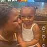 toddler, woman, child, indoor, kitchen, smiling, holding, text_overlay, love, affection, family, person, countertop, door, cabinet, hairstyle, white_clothing, emojis, portrait, happy